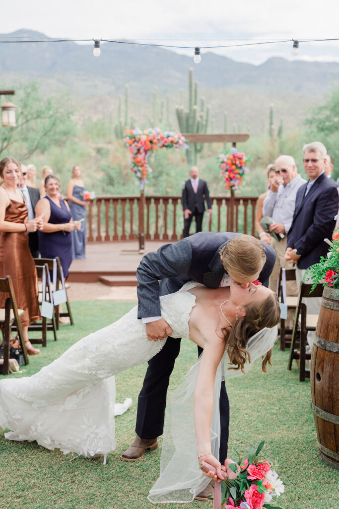 Close wedding film still of couple sharing vows during an outdoor ceremony.